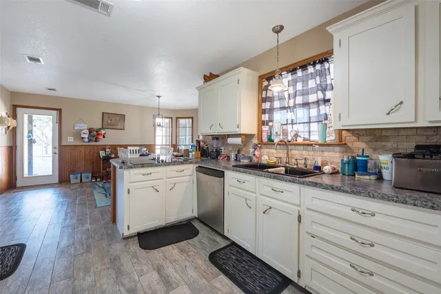 a kitchen with granite countertop white cabinets and white appliances