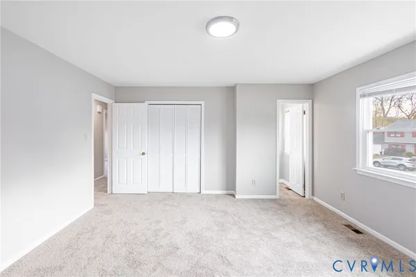 an empty room with windows and closet