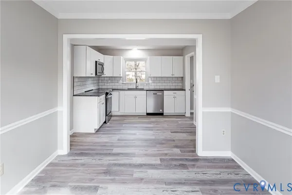a kitchen with granite countertop a sink cabinets and wooden floor
