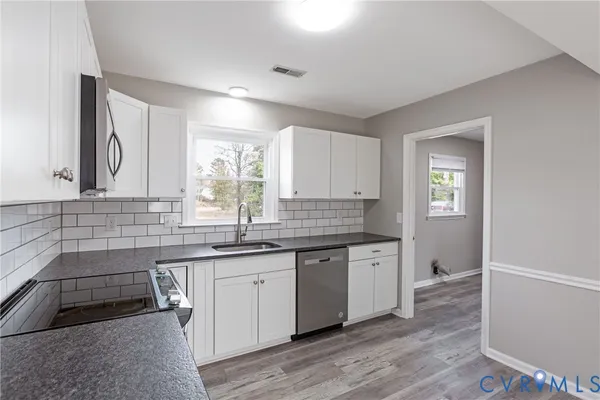 a kitchen with granite countertop a sink and cabinets