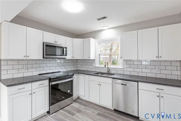 a kitchen with sink cabinets and appliances