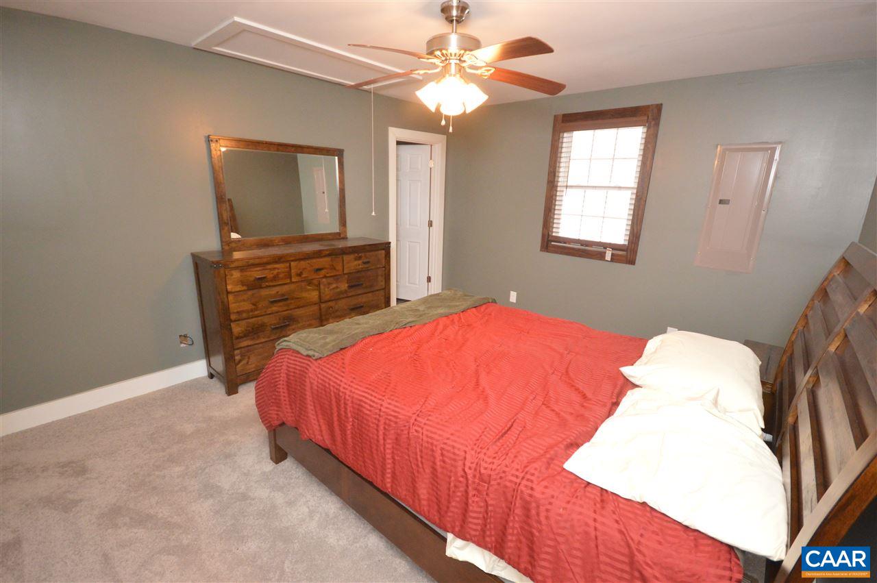 3633 Middle River Road Stanardsville, VA 22973 - Photo 16 of 26 a bedroom with a bed and a chandelier