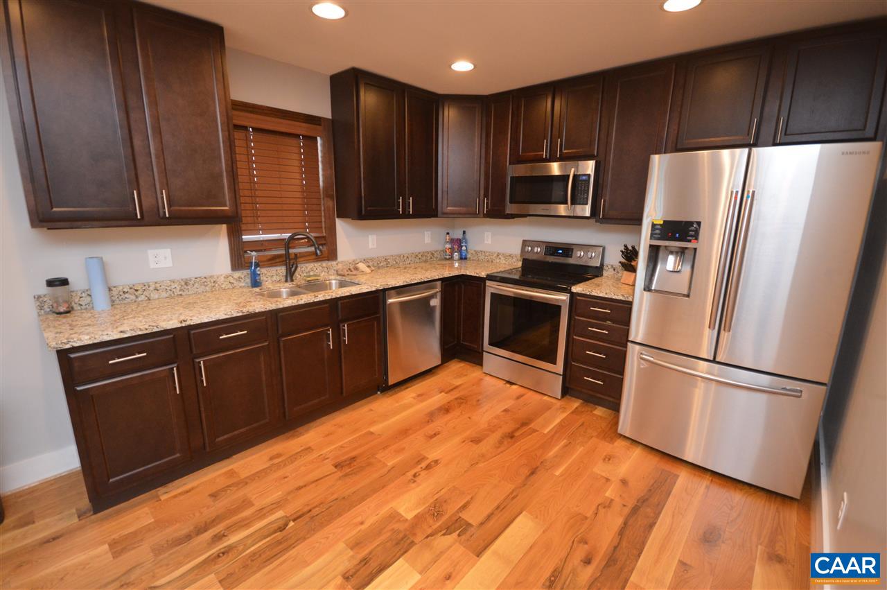 3633 Middle River Road Stanardsville, VA 22973 - Photo 9 of 26 a kitchen with stainless steel appliances granite countertop a refrigerator stove a sink dishwasher and wooden cabinets with wooden floor