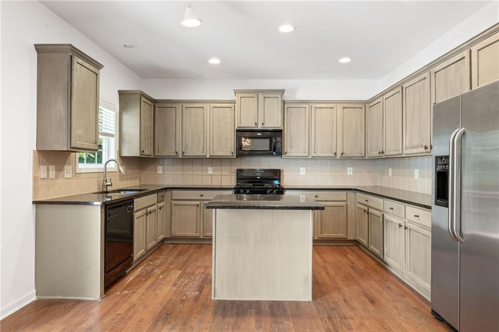 208 Sawtooth Court Canton, GA 30114 - Photo 12 of 31 a kitchen with stainless steel appliances granite countertop a stove top oven a sink a refrigerator and white cabinets with wooden floor