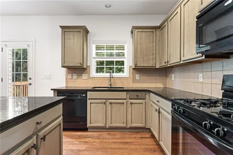 a kitchen with cabinets appliances a sink and a window