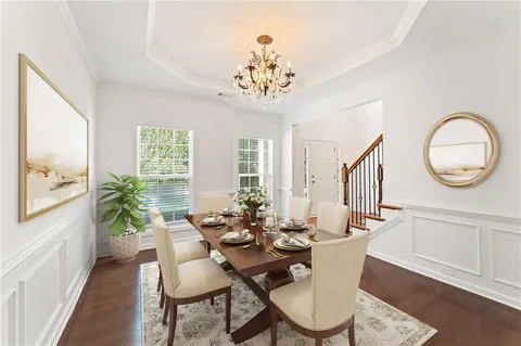 a view of a dining room with furniture a chandelier and wooden floor