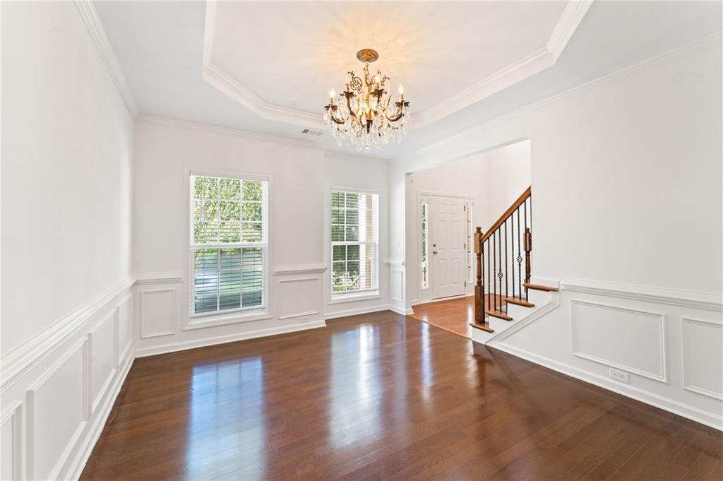 208 Sawtooth Court Canton, GA 30114 - Photo 6 of 31 an empty room with wooden floor chandelier and windows