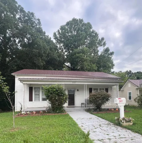 a front view of a house with a yard and potted plants