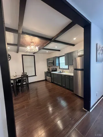 a view of a kitchen with furniture and a refrigerator