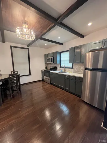 a kitchen with stainless steel appliances granite countertop a refrigerator stove top oven and sink