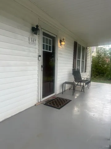 a view of a livingroom with chairs and table in a patio
