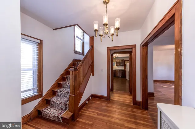 a view of a hallway with wooden floor and staircase