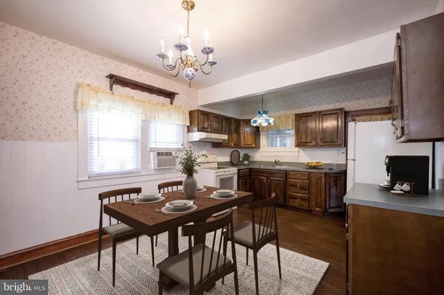 a view of a dining room with furniture a chandelier and wooden floor