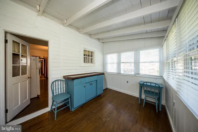 a kitchen with granite countertop a stove a sink and wooden floors