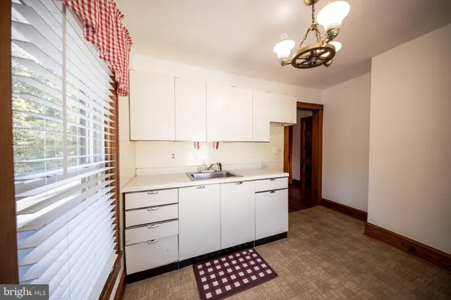 a kitchen with stainless steel appliances a sink cabinets and wooden floor
