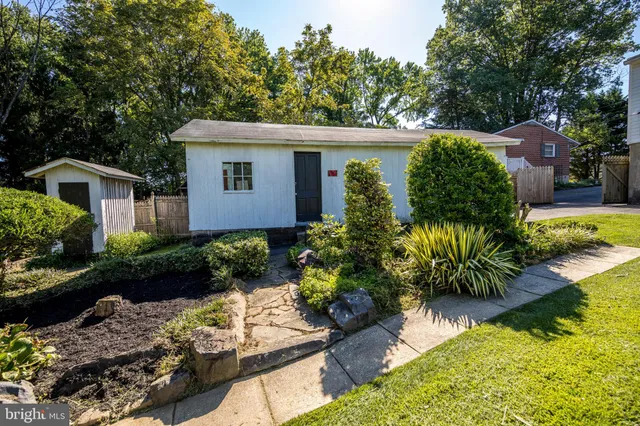 a front view of a house with a yard and a garden