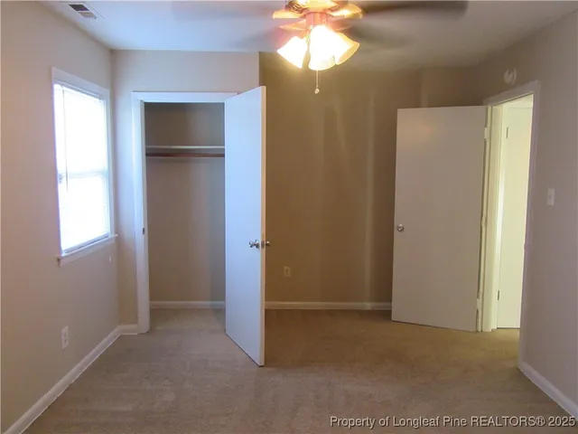 a view of empty room with window and wooden floor