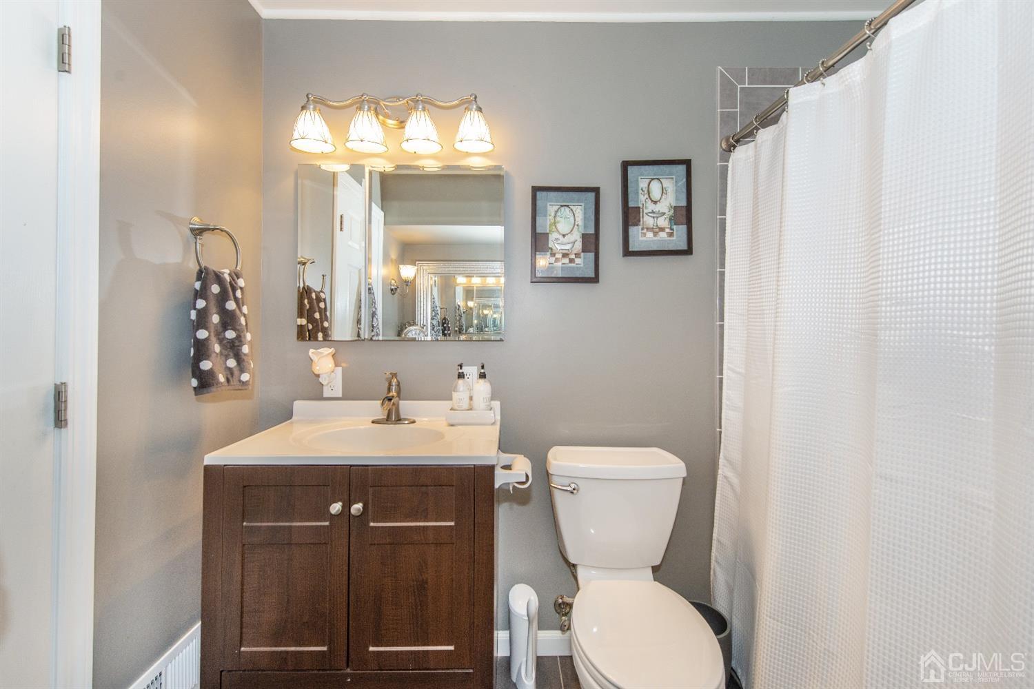 40 Longfellow Drive Colonia, NJ 07067 - Photo 11 of 24 a bathroom with a toilet a sink and mirror
