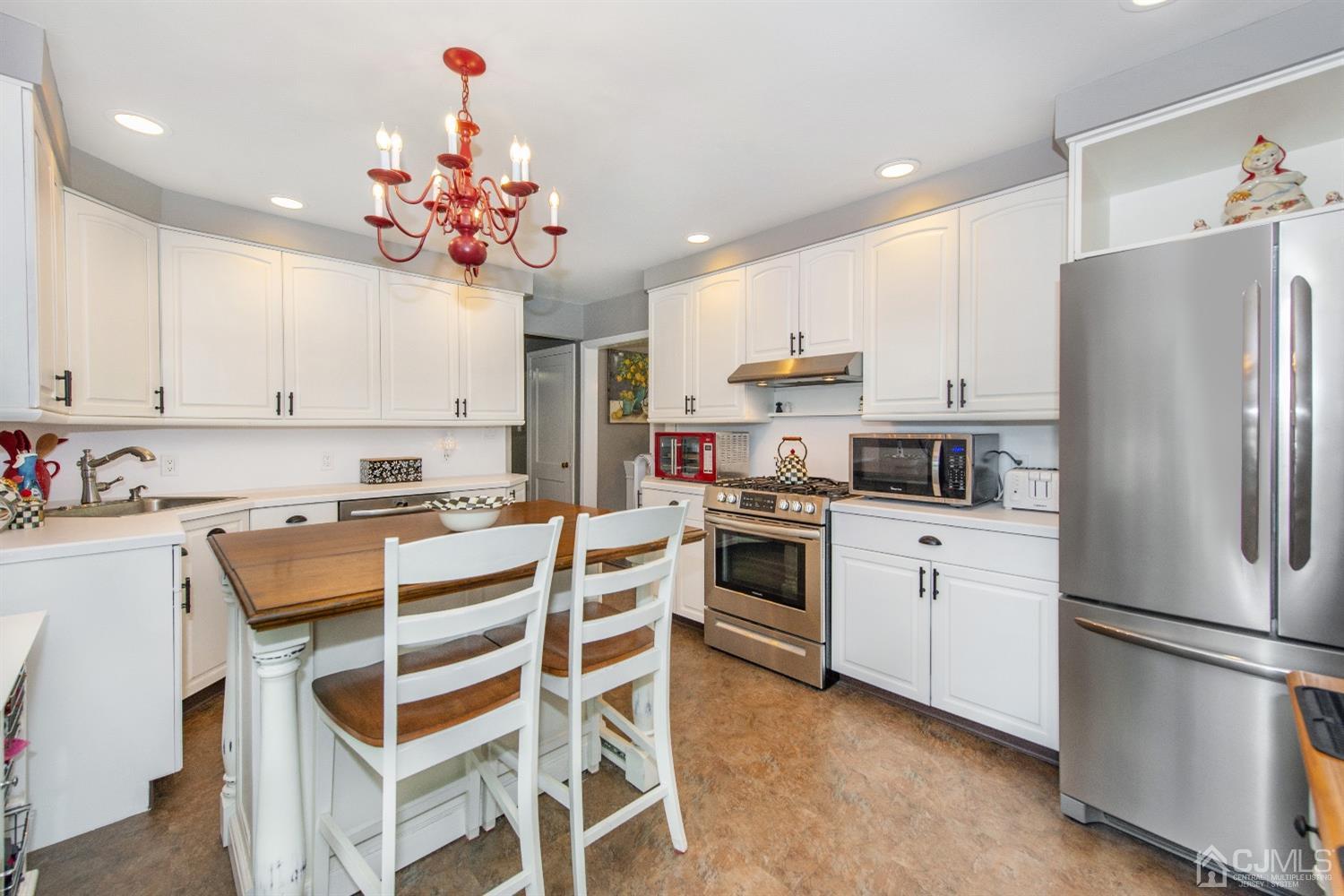 40 Longfellow Drive Colonia, NJ 07067 - Photo 8 of 24 a kitchen with kitchen island white cabinets and stainless steel appliances