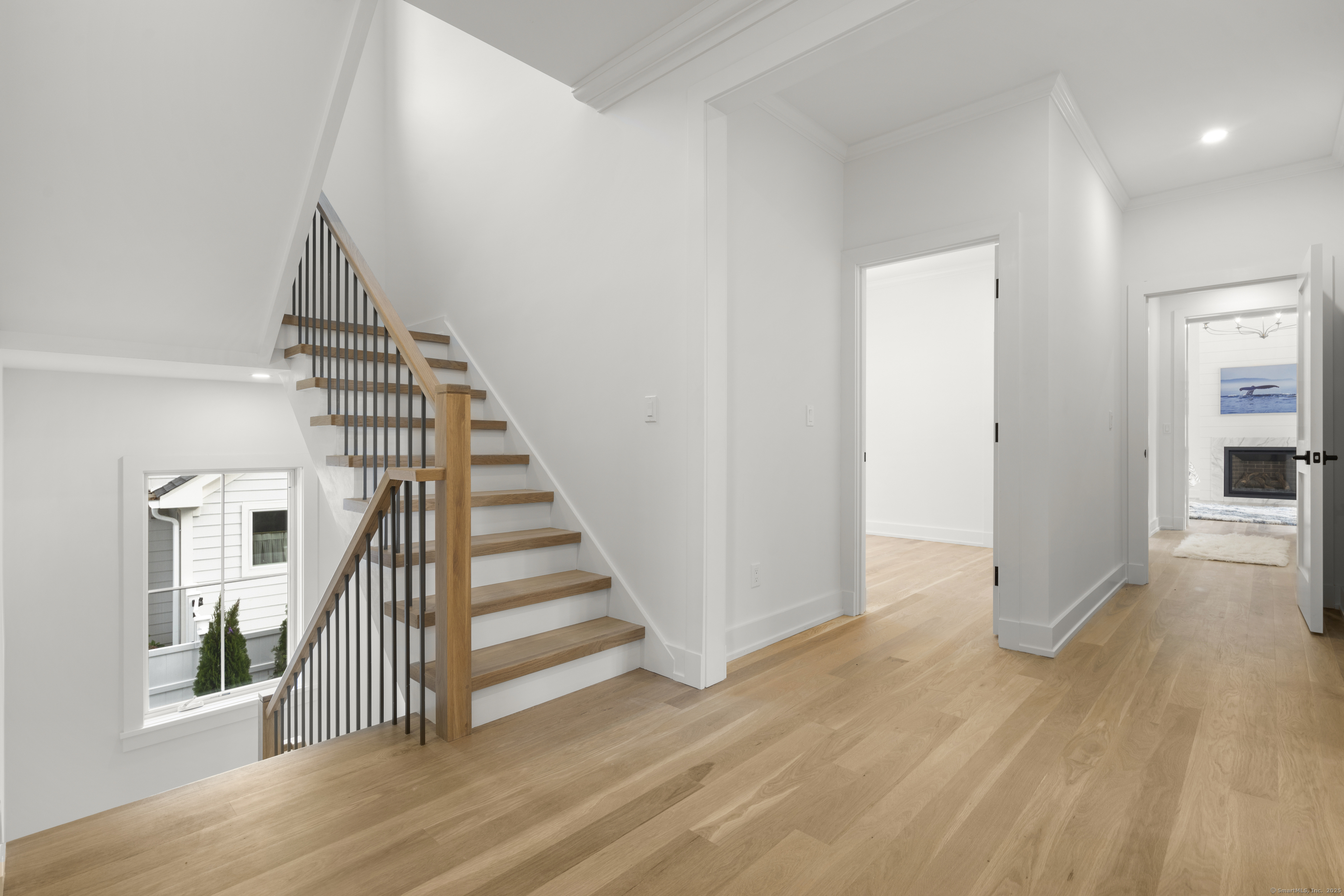 706 Judd Street Fairfield, CT 06824 - Photo 15 of 40 an entryway in a hall with wooden floor and stairs