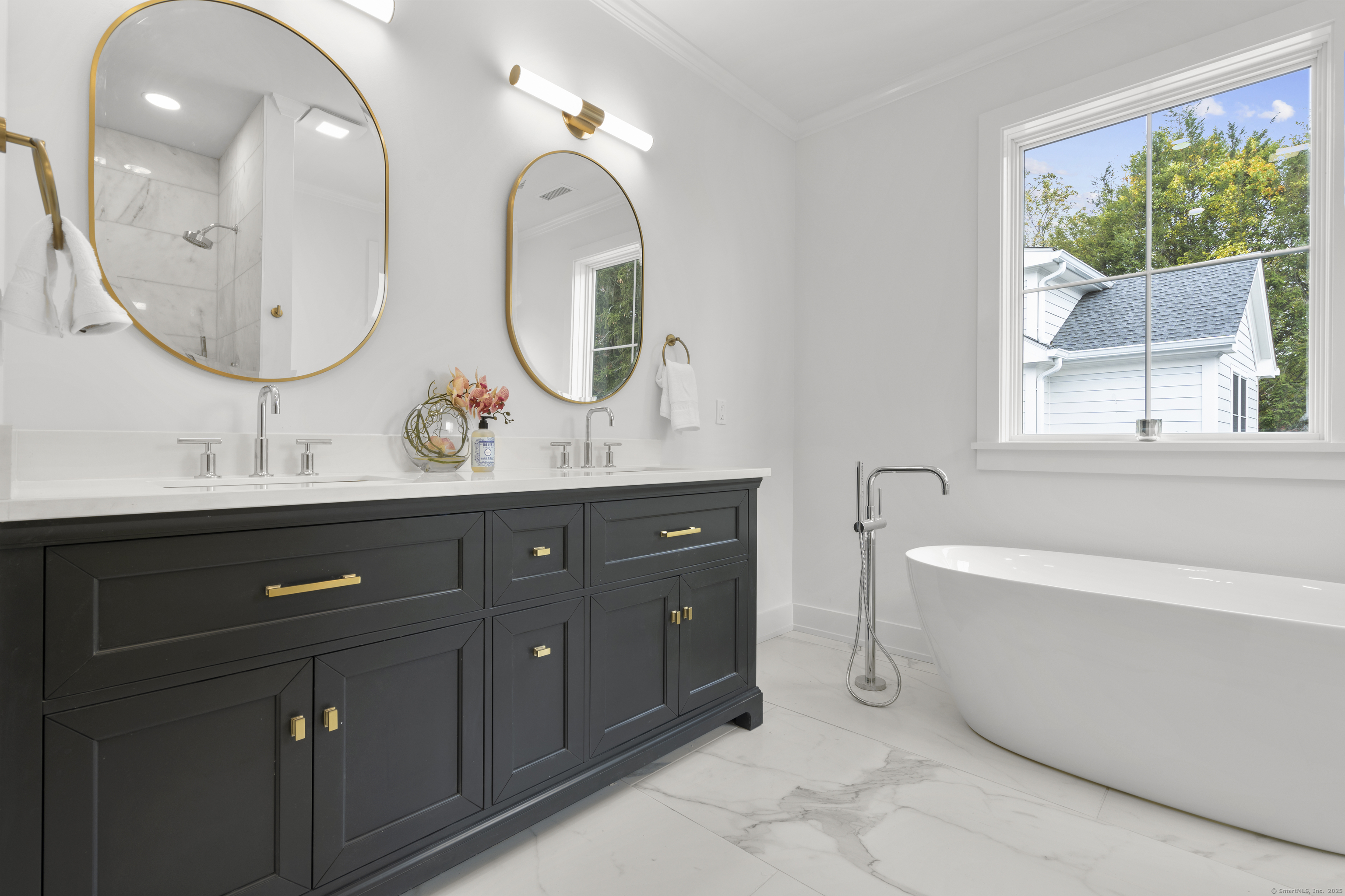 706 Judd Street Fairfield, CT 06824 - Photo 18 of 40 a bathroom with a double vanity sink a mirror and a bathtub next to a window