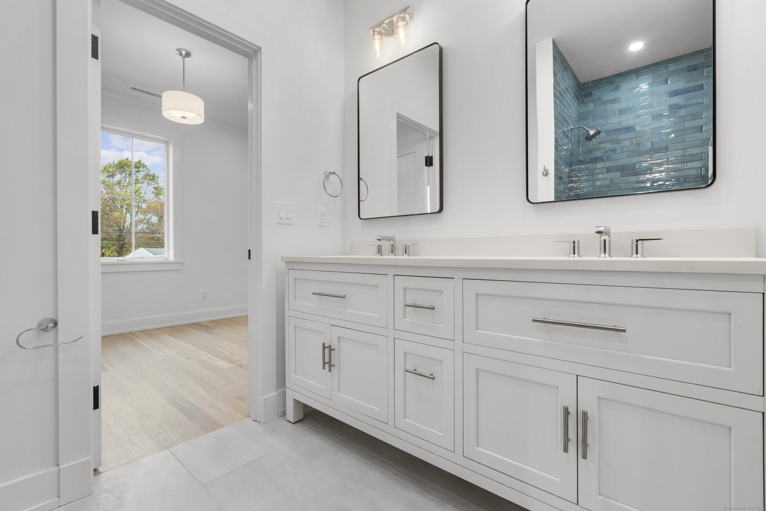 706 Judd Street Fairfield, CT 06824 - Photo 22 of 40 a bathroom with double vanity sink and a mirror