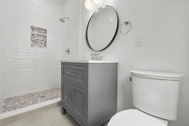 a bathroom with a sink a toilet and a mirror