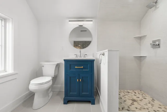 a bathroom with a toilet a sink and a mirror