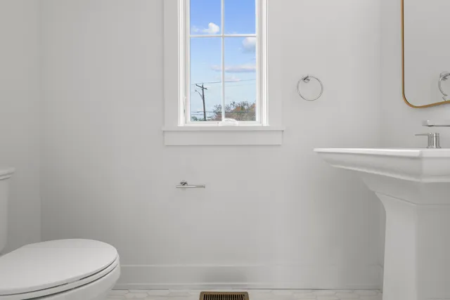 a bathroom with a sink mirror and toilet