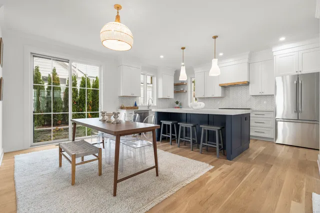 a kitchen with kitchen island a dining table chairs and a sink
