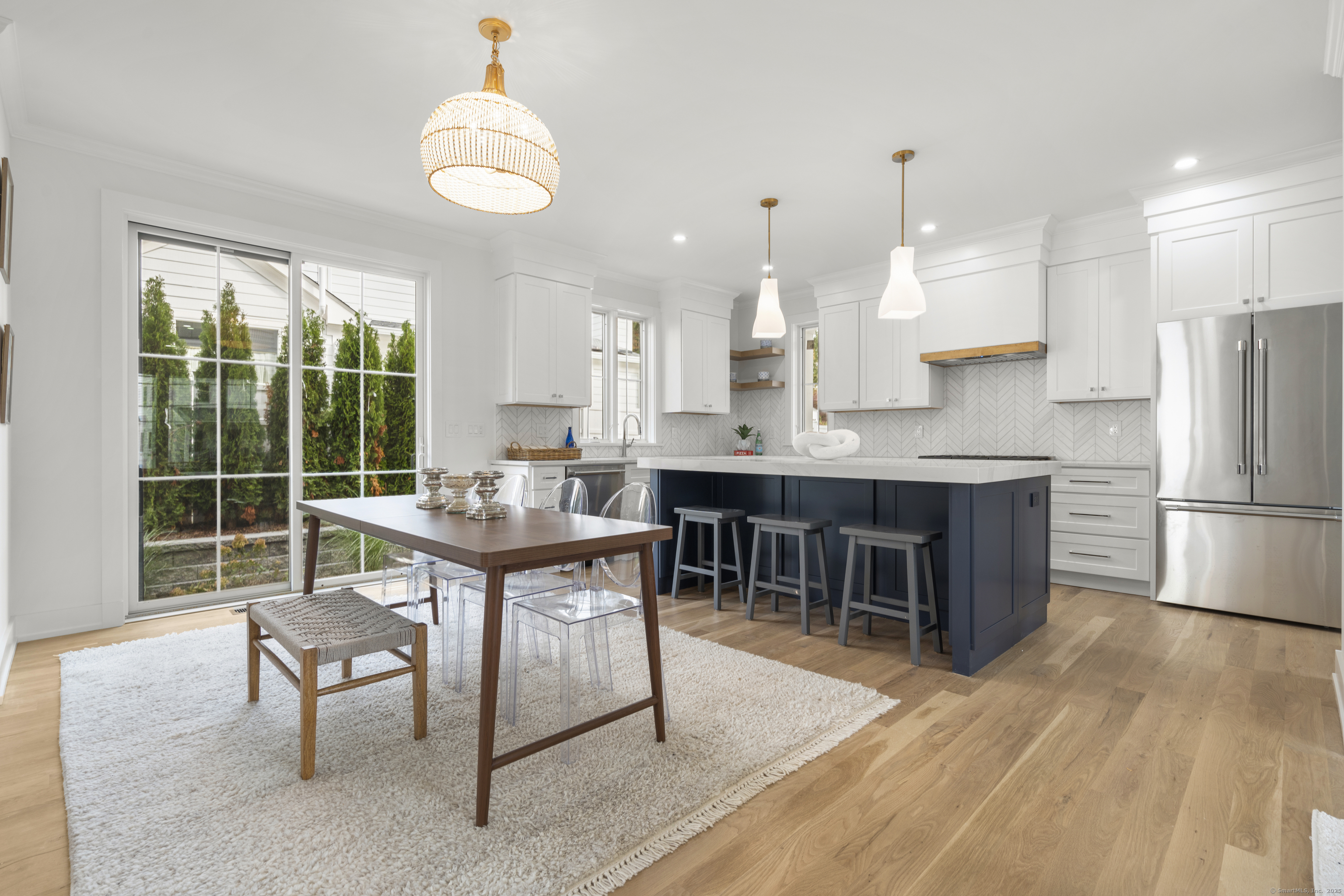 706 Judd Street Fairfield, CT 06824 - Photo 10 of 40 a kitchen with kitchen island a dining table chairs and a sink