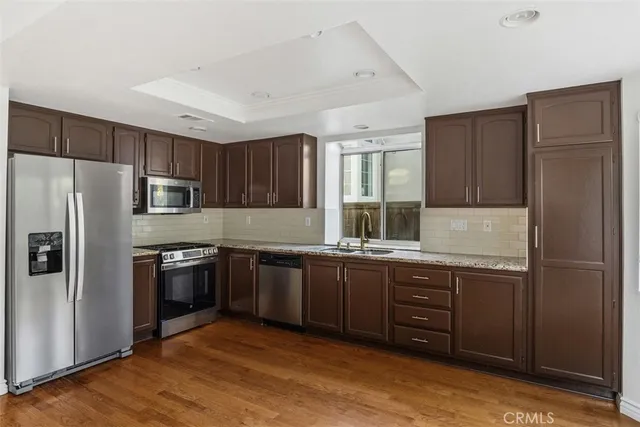 a kitchen with stainless steel appliances granite countertop a refrigerator stove and sink