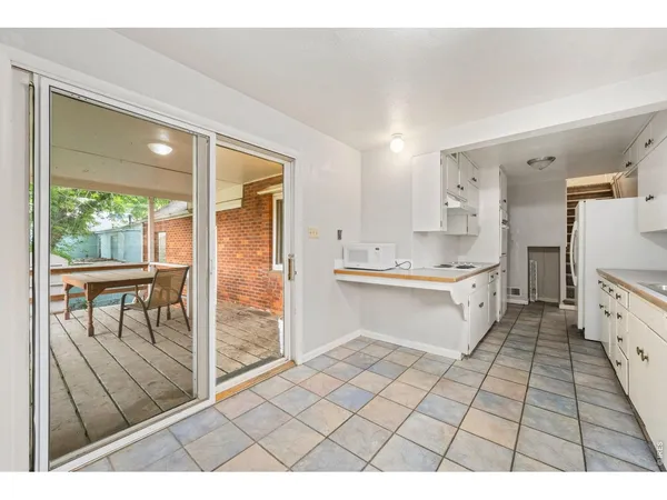 a open kitchen with granite countertop a stove a sink and a refrigerator