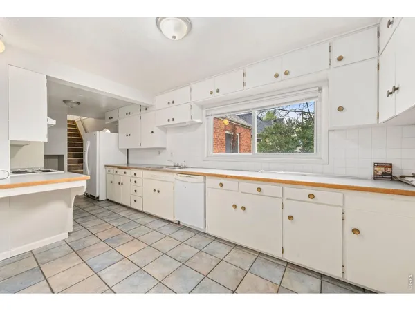 a large white kitchen with cabinets