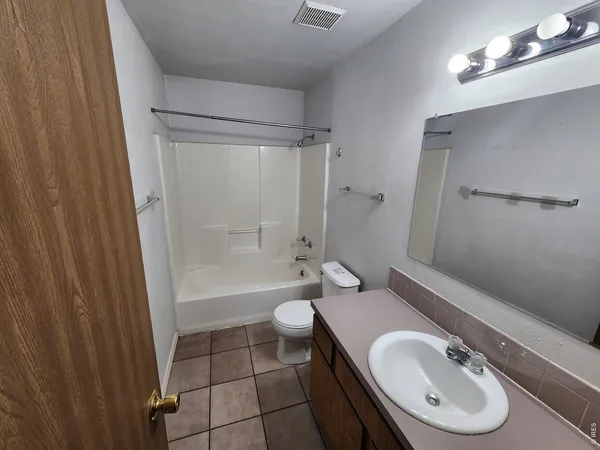 a bathroom with a sink a toilet a mirror and shower