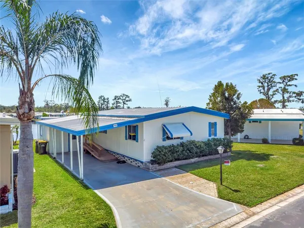 a view of a house with backyard and sitting area