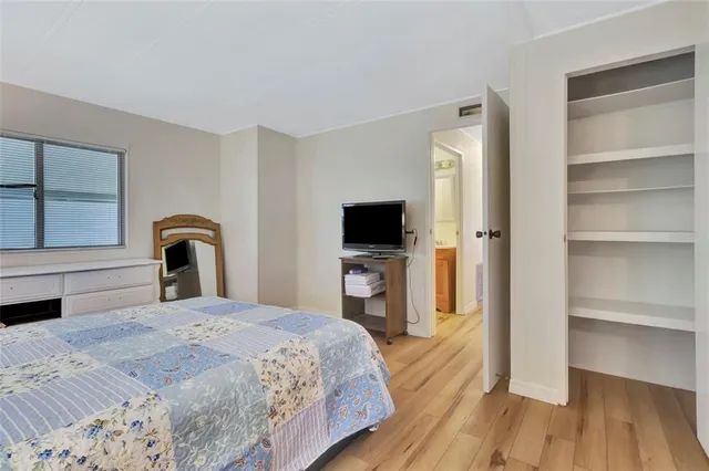 a bedroom with a large bed and a flat tv screen on dresser