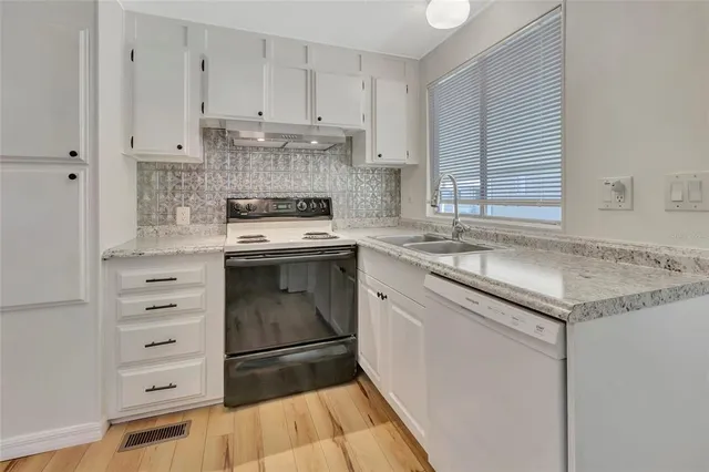 a kitchen with granite countertop cabinets stainless steel appliances and a sink
