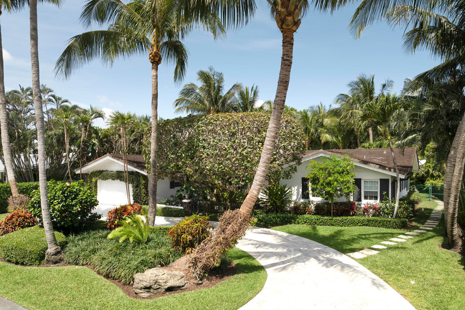 1125 Harbor Drive Delray Beach, FL 33483 - Photo 5 of 41 a front view of a house with a yard and palm trees
