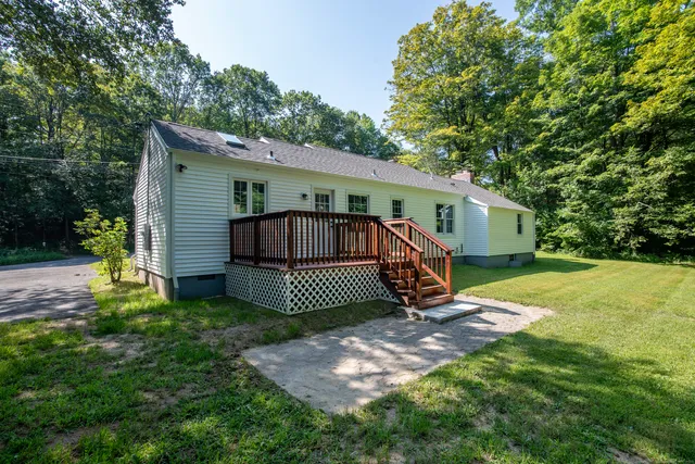 a view of a house with a yard and deck