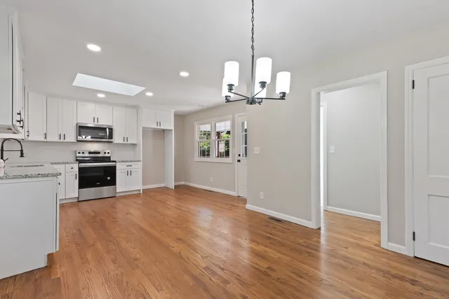 a view of a kitchen with a sink a kitchen microwave and cabinets