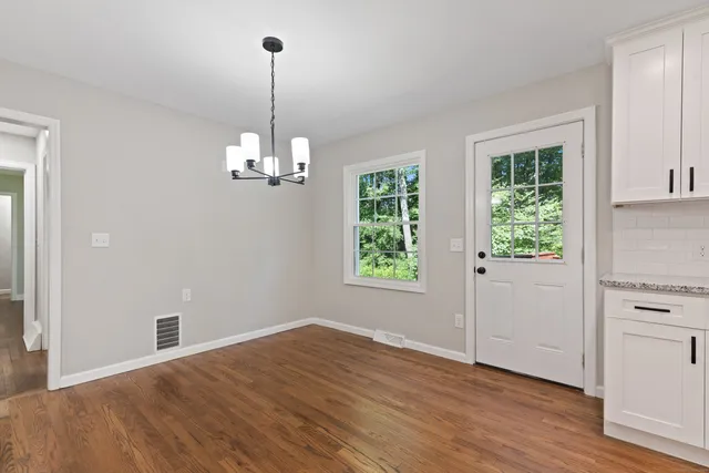 a view of a livingroom with wooden floor and window