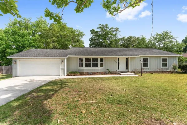 a front view of house with yard and trees