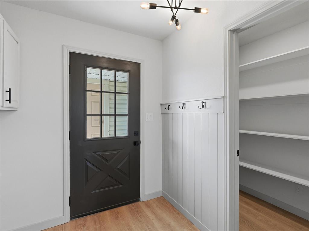 289 County Road 4655 Rhome, TX 76078 - Photo 5 of 34 Contemporary light fixture, a coat rack with four hooks, and a pantry with built-in shelving