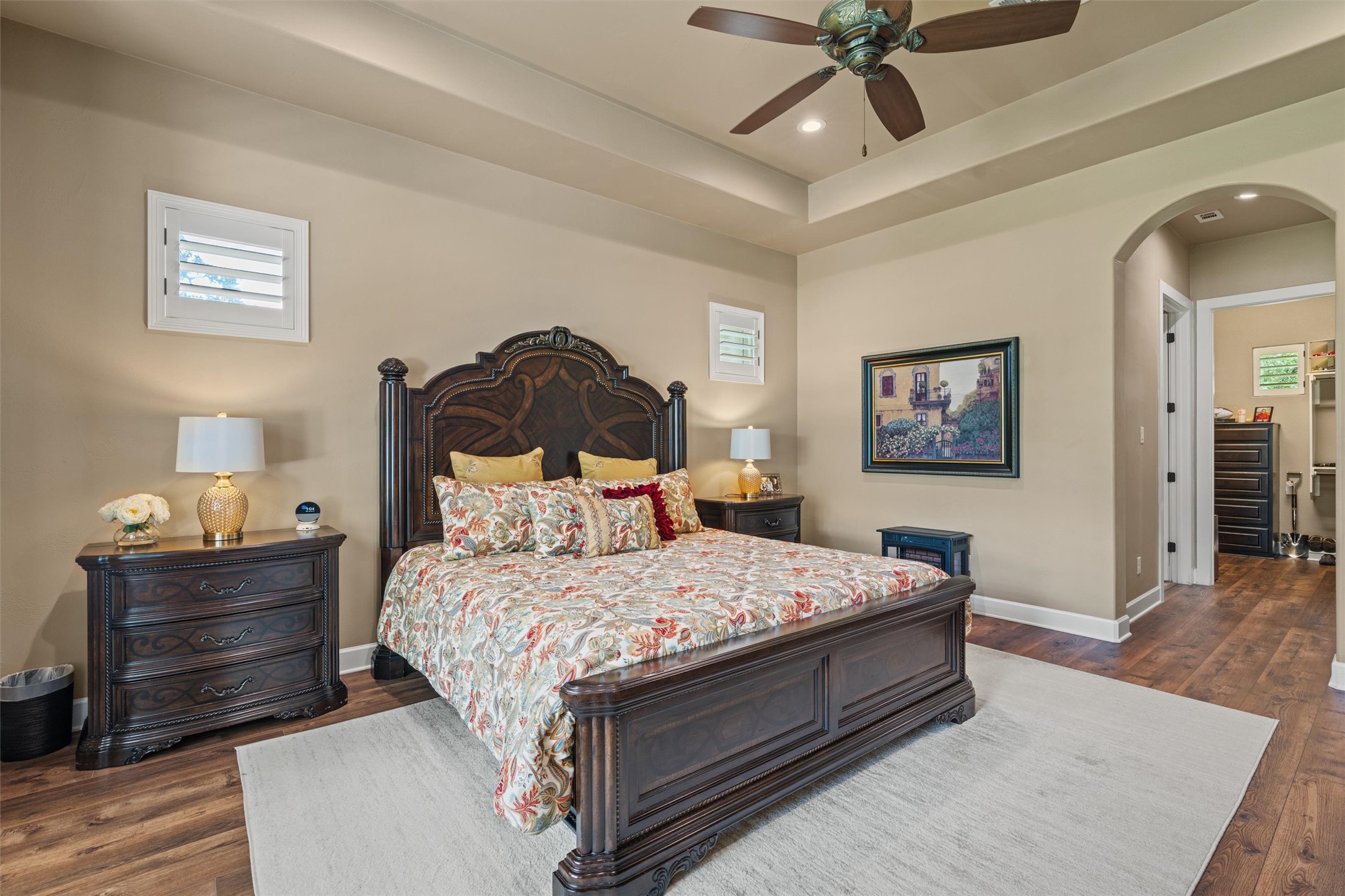 104 Adobe Cove Georgetown, TX 78633 - Photo 13 of 39 Bedroom with arched walkways, dark wood finished floors, ceiling fan, a tray ceiling, and recessed lighting