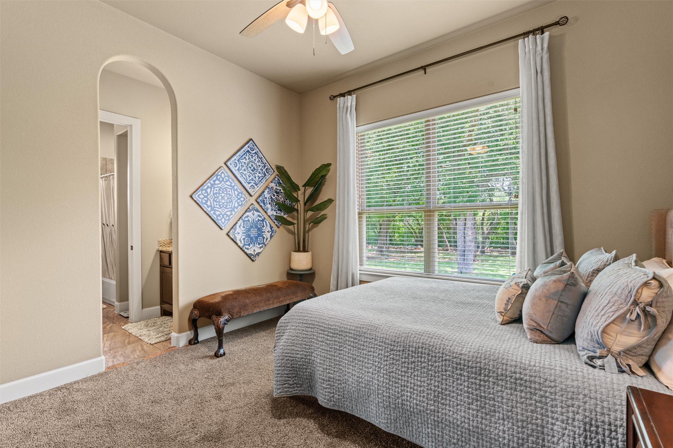 104 Adobe Cove Georgetown, TX 78633 - Photo 23 of 39 Bedroom featuring arched walkways, ceiling fan, light carpet, and connected bathroom
