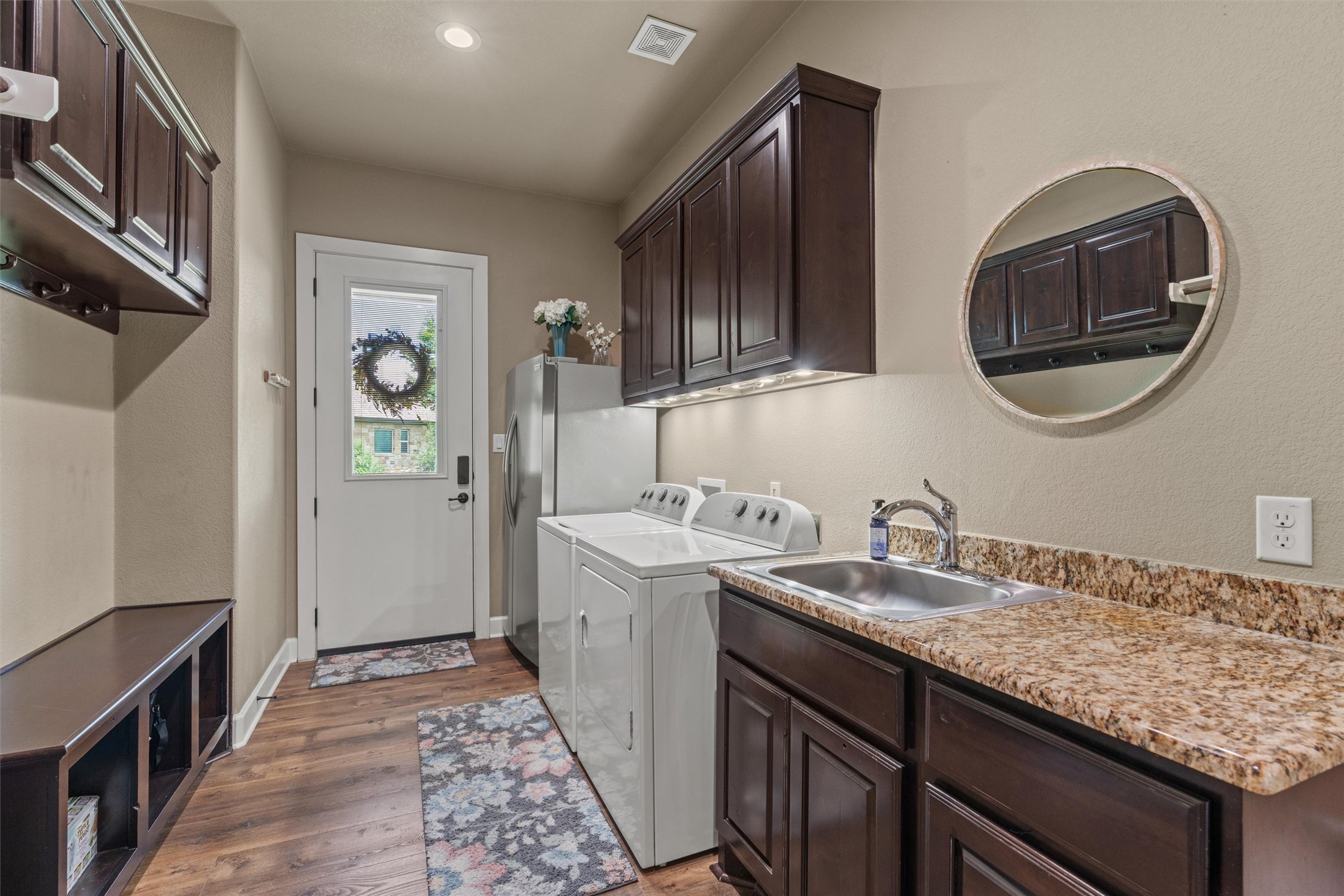 104 Adobe Cove Georgetown, TX 78633 - Photo 26 of 39 Laundry area with light wood-style floors, washer and dryer, and cabinet space