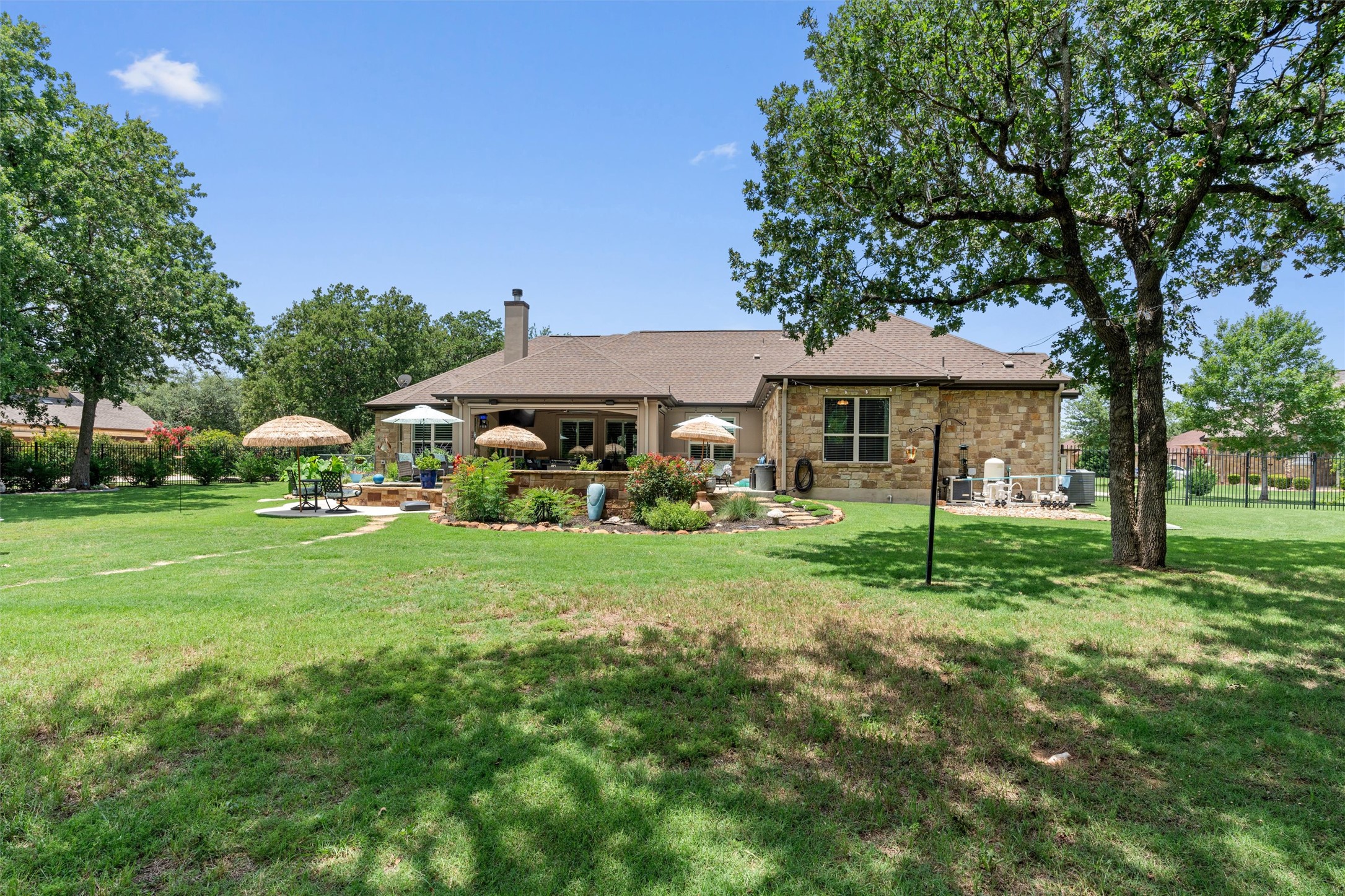 104 Adobe Cove Georgetown, TX 78633 - Photo 35 of 39 Back of house featuring a patio, a chimney, a lawn, and stone siding