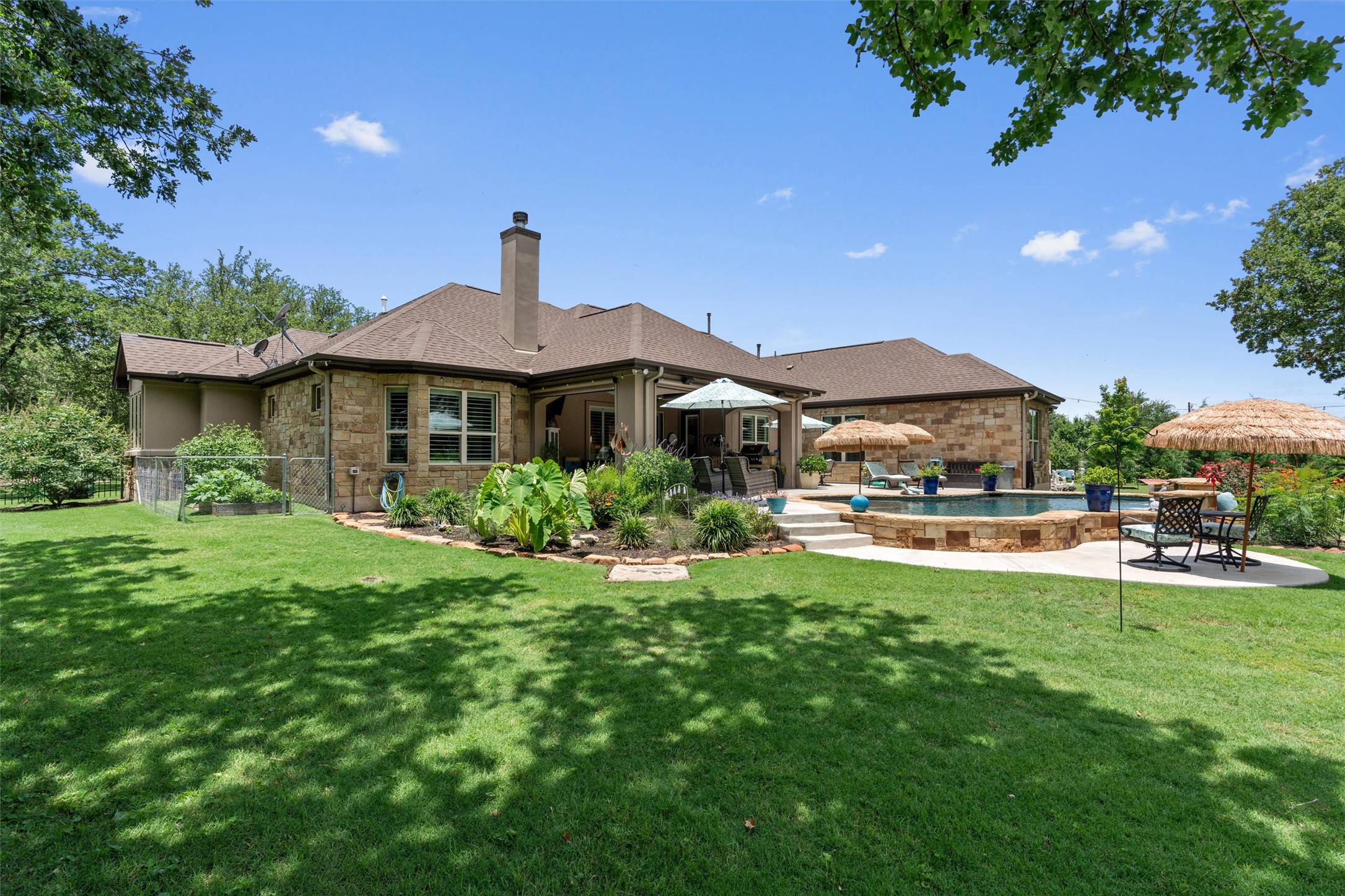 104 Adobe Cove Georgetown, TX 78633 - Photo 38 of 39 Rear view of house with a patio area, an outdoor pool, a chimney, a yard, and stone siding