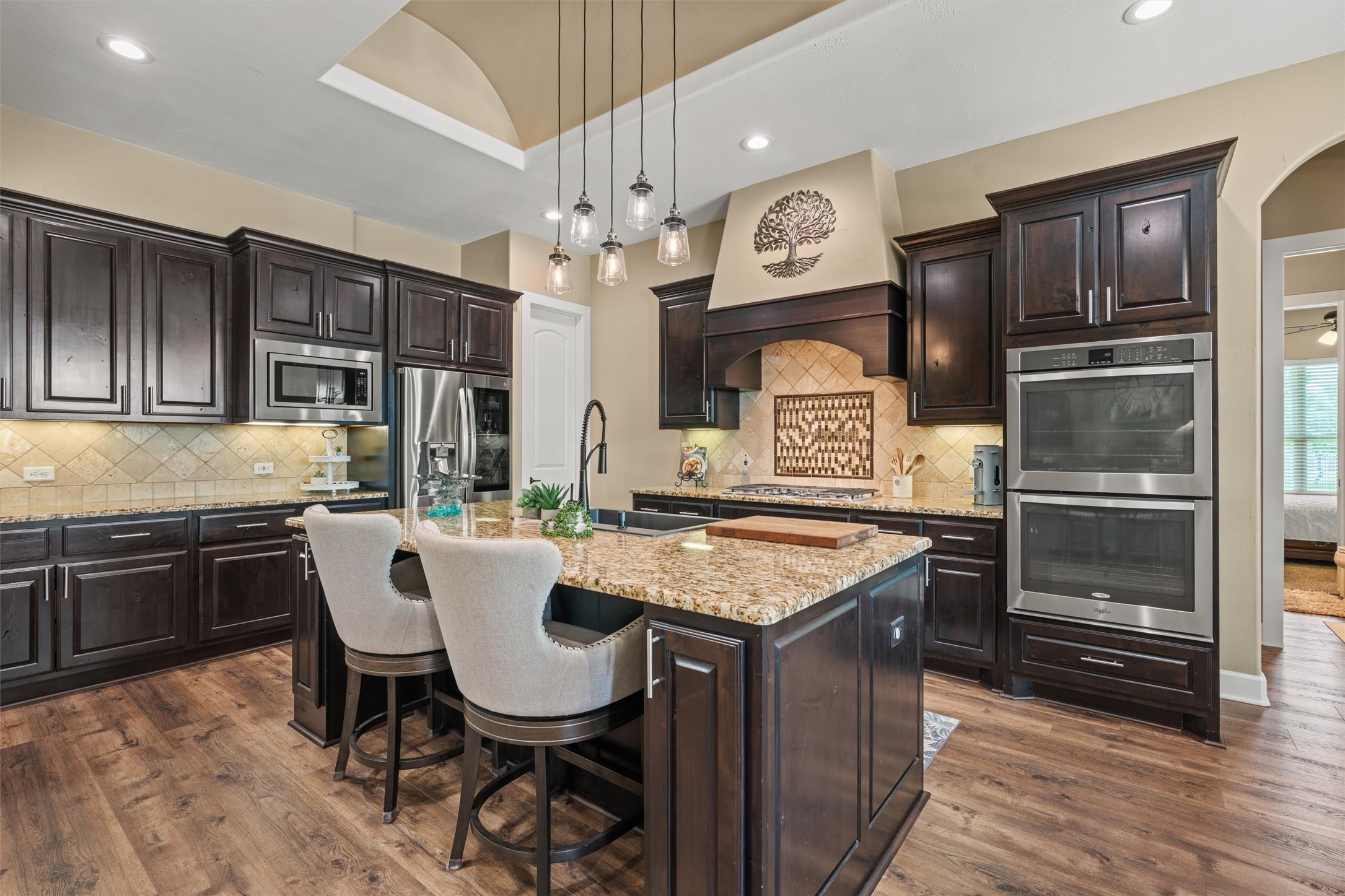 104 Adobe Cove Georgetown, TX 78633 - Photo 9 of 39 Kitchen featuring light stone counters, stainless steel appliances, pendant lighting, and dark wood finish cabinets
